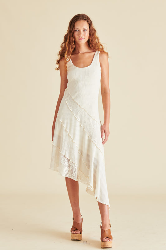 A woman looking confident in an off-white dress with a diagonal hemline.