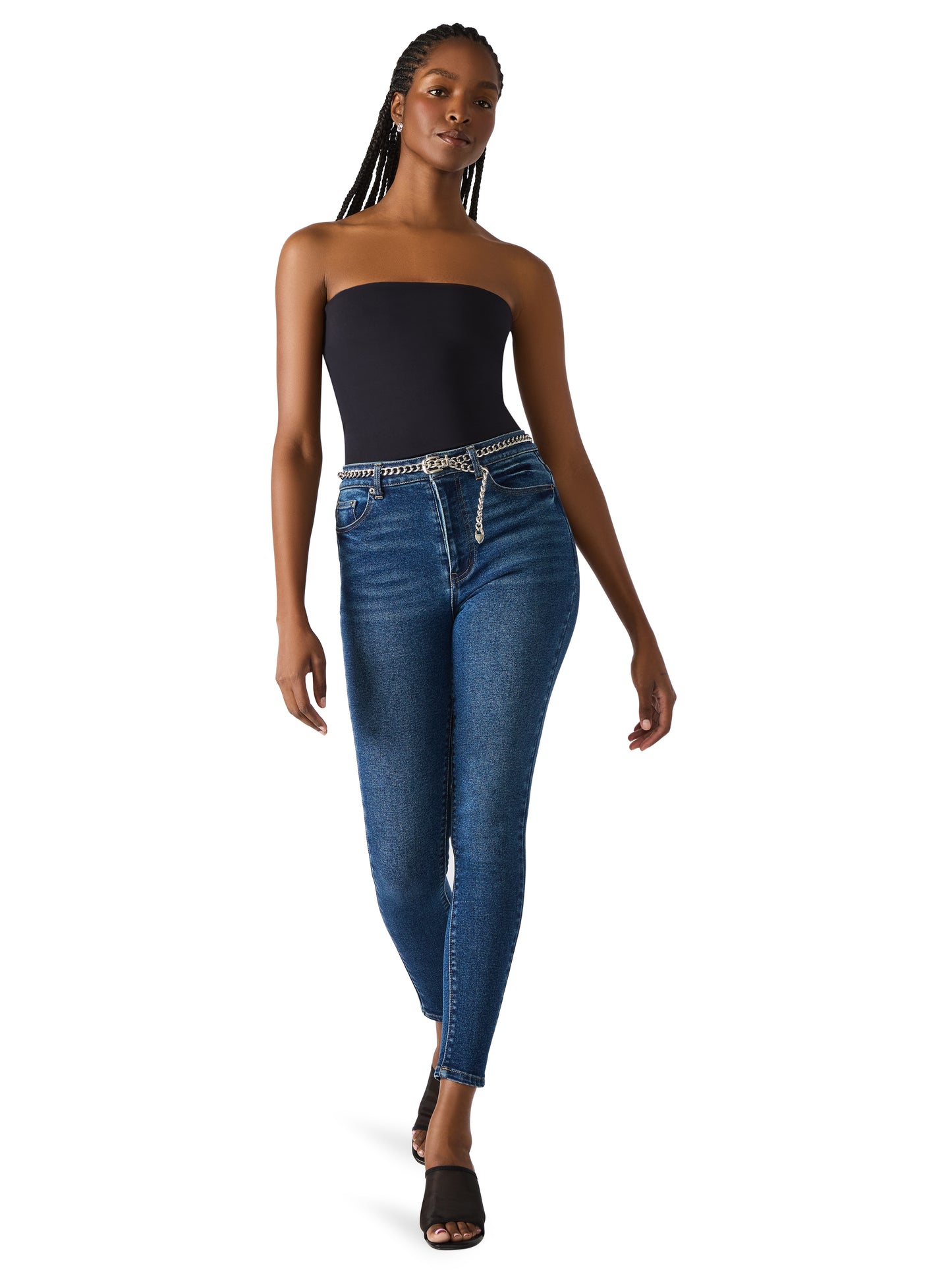 Woman wearing a strapless black top and blue jeans on a white background
