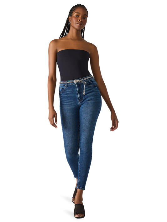 Woman wearing a strapless black top and blue jeans on a white background