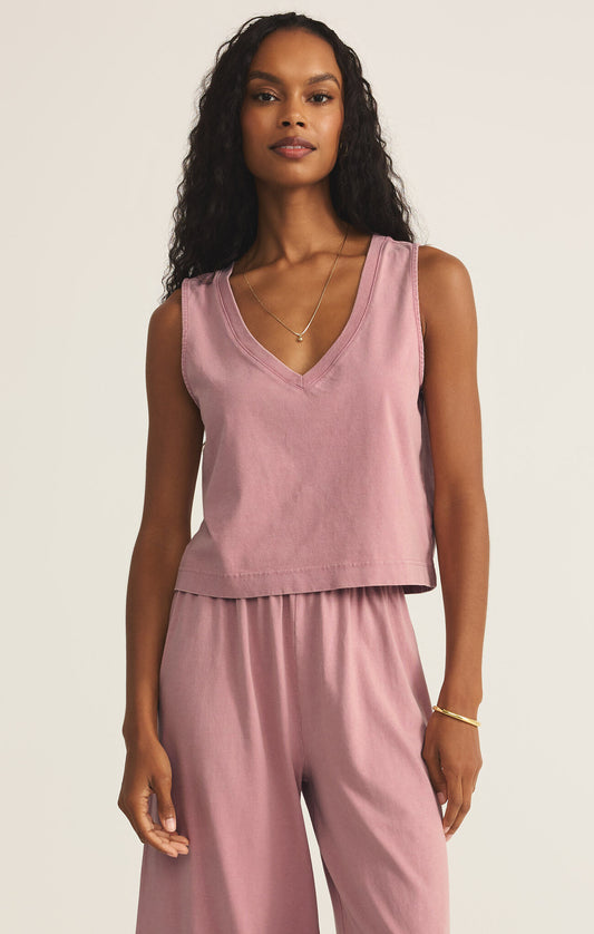 A woman wearing a pink sleeveless v-neck top paired with matching pants.