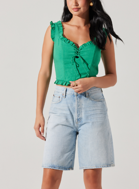Image of woman wearing green ruffled tank top.